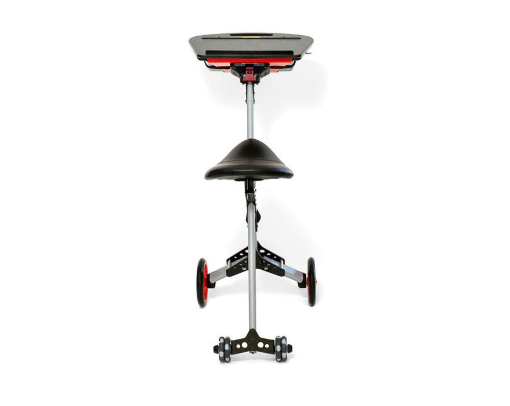 An image of a mobile ergonomic workstation with a height-adjustable pole, a black saddle seat, and a red and black tray top labeled 'TurboDesk'. It has a sturdy five-wheel base with two large red wheels and three smaller black wheels, offering stability and mobility. 